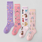 Flat lay display featuring four pairs of Disney Princess knee-high compression socks lined up side-by-side, including Magic Carriage & Lamp (lilac), Princess Icons (pink), Character Collage (light pink), and Cinderella (soft pink), all featuring "WOOF" top cuff branding.