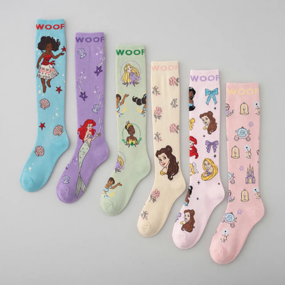 Flat lay display showcasing six pairs of Disney Princess knee-high compression socks lined up side-by-side, including Moana (aqua), Ariel (purple), Multi-Princess (mint green), Belle (cream), Character Collage (light pink), and Cinderella (soft pink), all featuring "WOOF" top cuff branding.