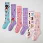 Flat lay display showcasing seven pairs of Disney Princess knee-high compression socks lined up side-by-side, including Moana (aqua), Ariel (purple), Princess Icons (pink), Magic Carriage & Lamp (lilac), Character Collage (light pink), and Cinderella (soft pink), all featuring "WOOF" top cuff branding.