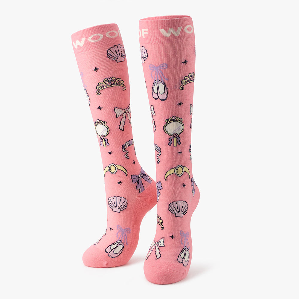 Side-by-side standing display of the pink Disney Princess knee-high compression socks printed with bow, tiara, mirror, and shell motifs.