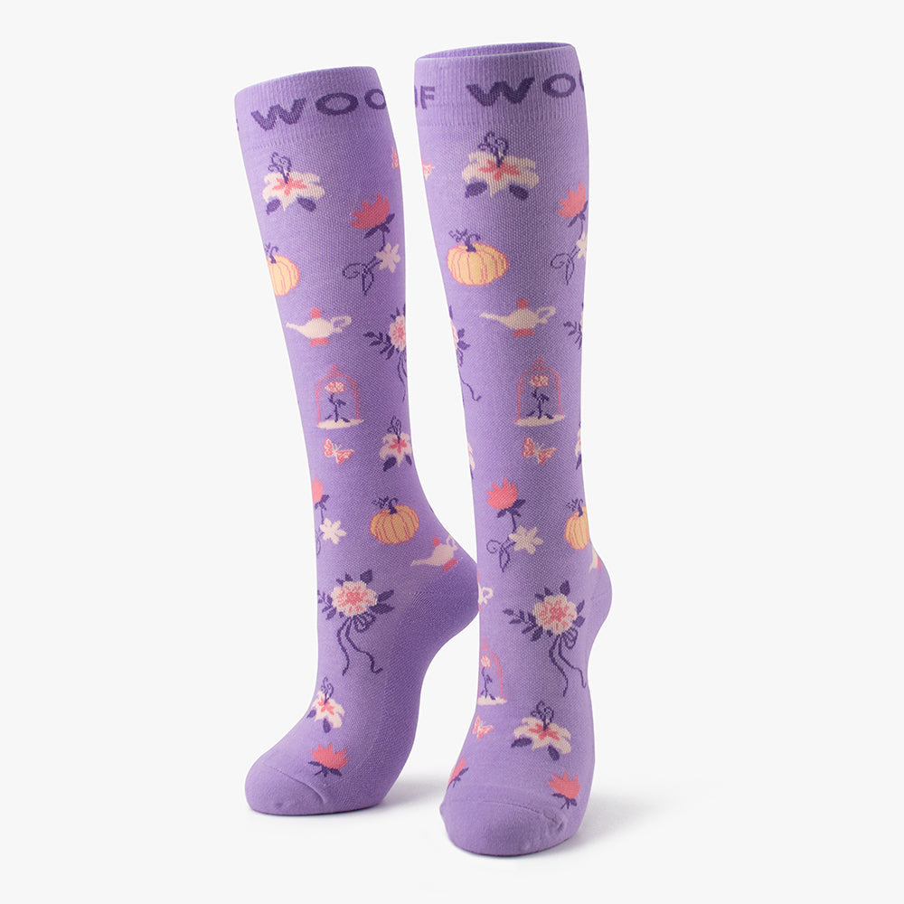 Side-by-side standing display of the lilac/purple Disney Princess knee-high compression socks printed with pumpkin carriages and magical lamps.