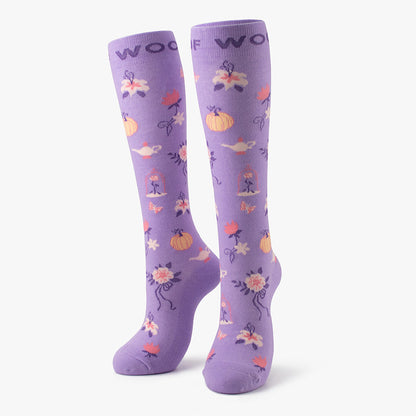 Side-by-side standing display of the lilac/purple Disney Princess knee-high compression socks printed with pumpkin carriages and magical lamps.