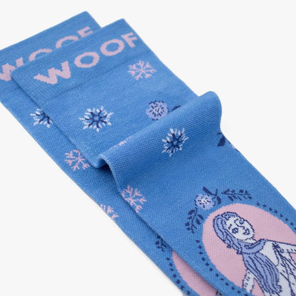 Folded view of cornflower blue knee-high compression socks displaying the Disney Frozen Elsa portrait and snowflake pattern alongside the "WOOF" top cuff tag.